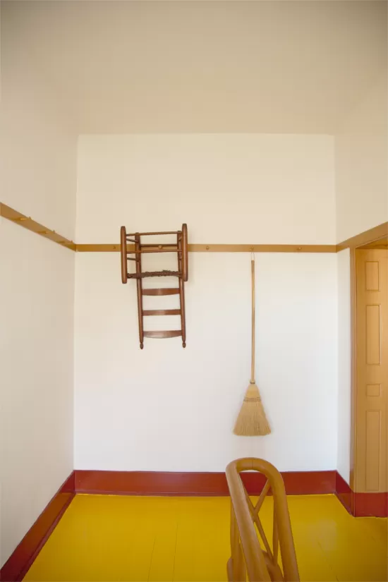 Chair hanging from rail with broom