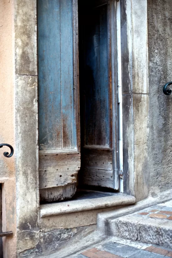 Faded blue wooden door alightly ajar