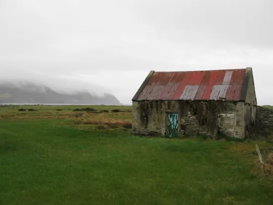 Old barn with metal roof in fog
