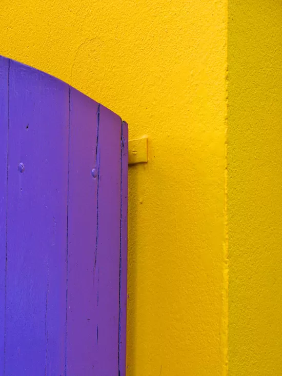Yellow wall with purple shutter