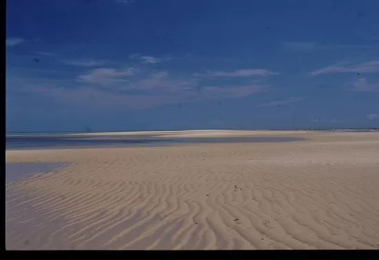 Patterns in beach sand under blue sky